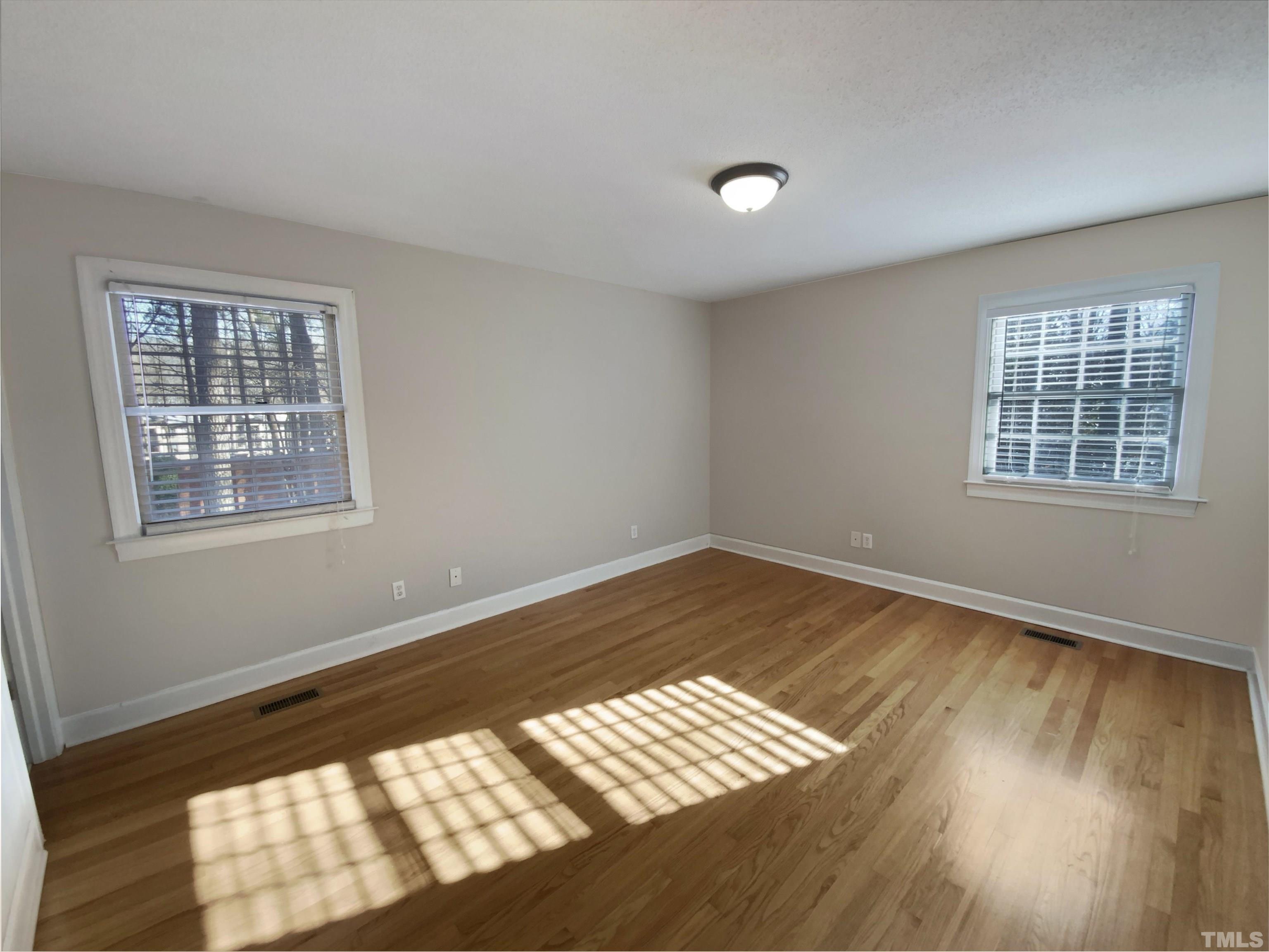 3200 Caldwell Drive Raleigh, NC 27607 - Photo 7 of 19 a view of an empty room with wooden floor and a window