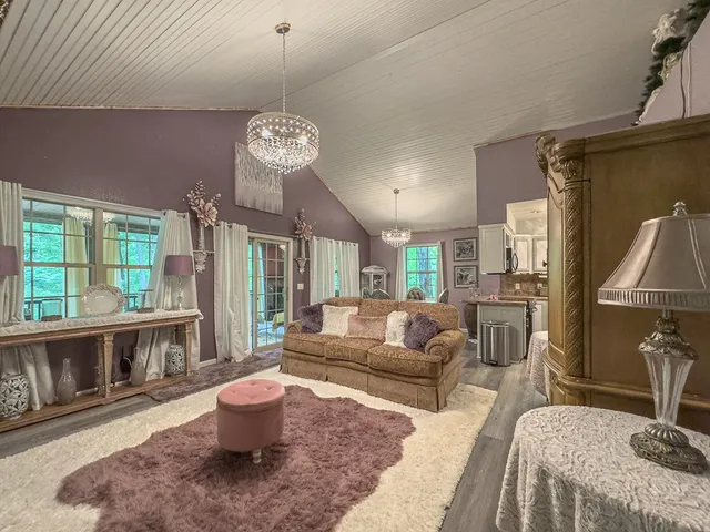 a living room with furniture a chandelier and a dining table
