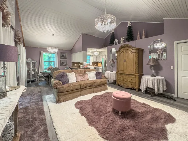 a living room with kitchen island furniture and a chandelier