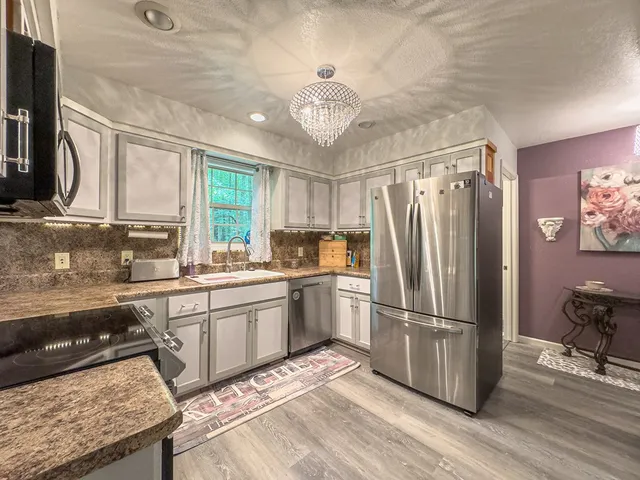a kitchen with stainless steel appliances granite countertop a sink and a stove