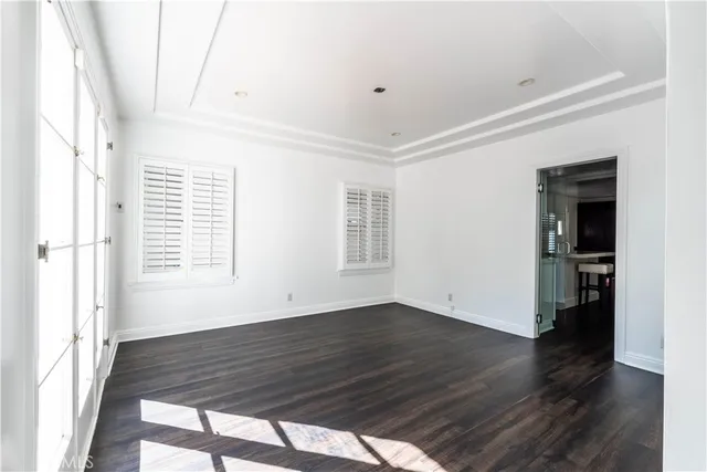 an empty room with wooden floor and a ceiling fan