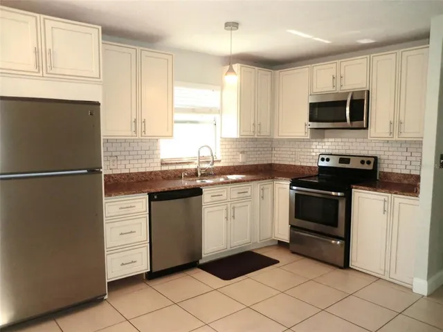 a kitchen with a sink stove and microwave