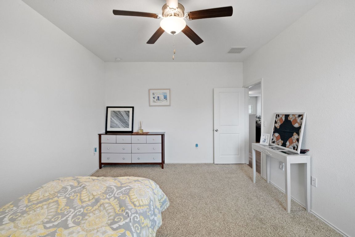 7116 Spirit Hill Road Austin, TX 78744 - Photo 17 of 33 Carpeted bedroom with a ceiling fan and baseboards