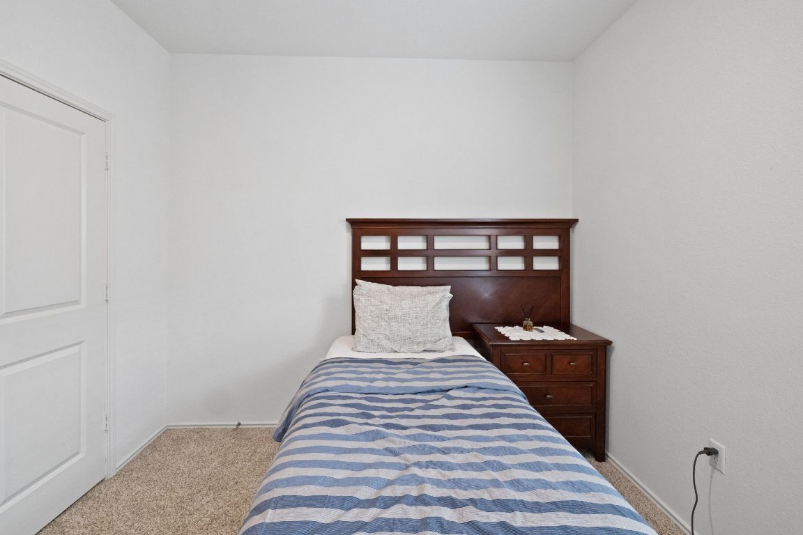 7116 Spirit Hill Road Austin, TX 78744 - Photo 23 of 33 Carpeted bedroom featuring baseboards