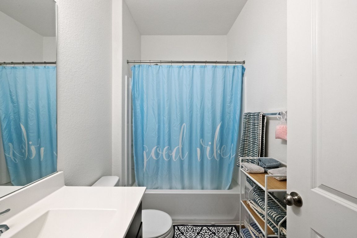 7116 Spirit Hill Road Austin, TX 78744 - Photo 25 of 33 Full bathroom featuring shower / bath combination with curtain and vanity