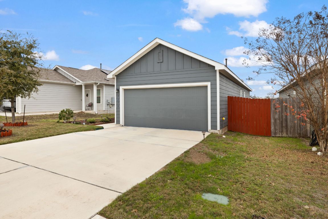 7116 Spirit Hill Road Austin, TX 78744 - Photo 3 of 33 Ranch-style home with board and batten siding, concrete driveway, and a garage