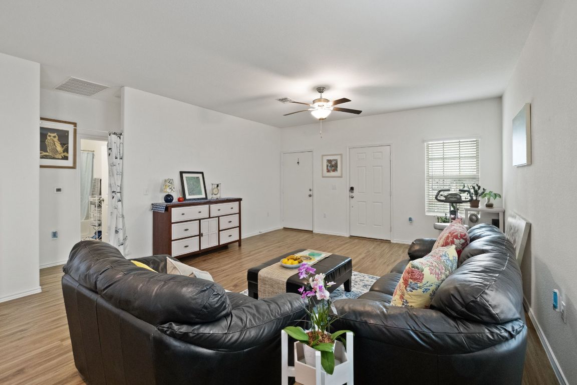 7116 Spirit Hill Road Austin, TX 78744 - Photo 10 of 33 Living room with a ceiling fan and light wood-style floors