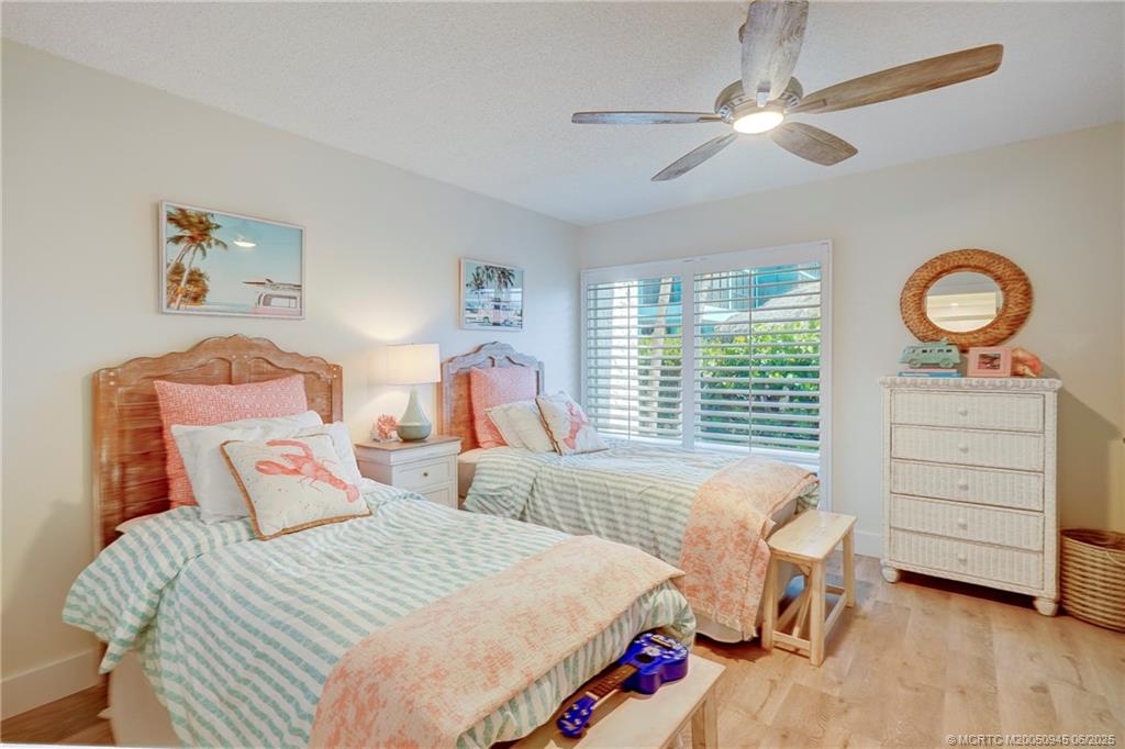 245 Northeast MacArthur Boulevard, Unit 11 Stuart, FL 34996 - Photo 11 of 47 a bedroom with a bed and a chandelier
