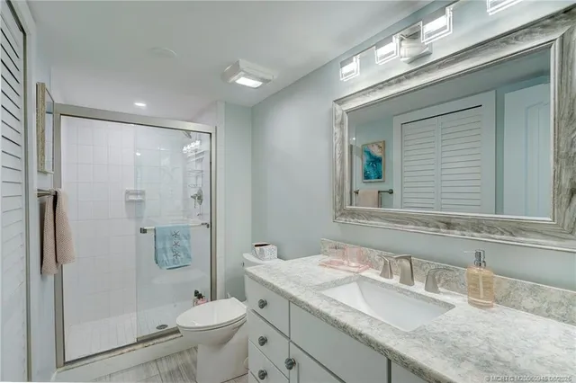 a bathroom with a granite countertop sink toilet and shower