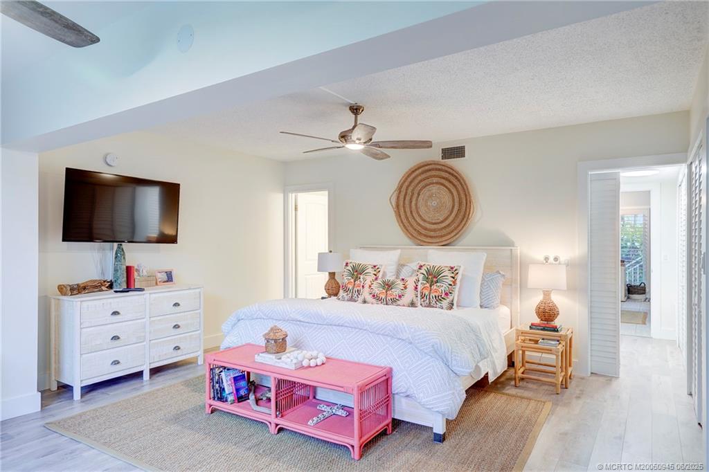 245 Northeast MacArthur Boulevard, Unit 11 Stuart, FL 34996 - Photo 16 of 47 a bedroom with furniture and a flat screen tv