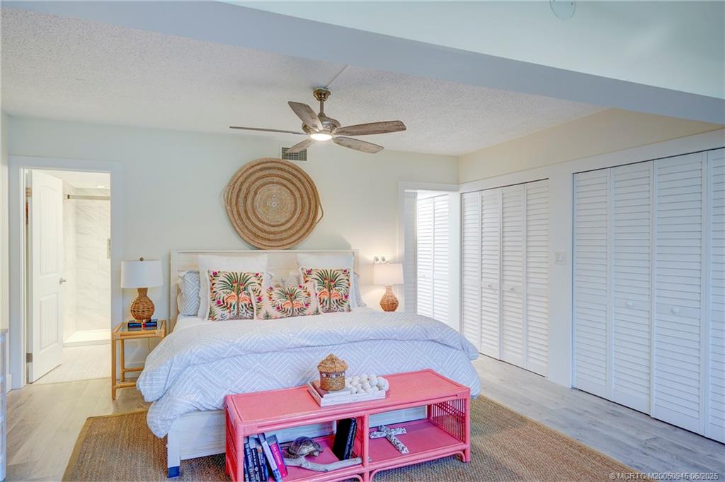 245 Northeast MacArthur Boulevard, Unit 11 Stuart, FL 34996 - Photo 17 of 47 a bedroom with furniture and a chandelier