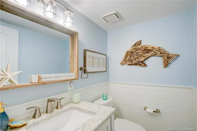 a bathroom with a sink a toilet and mirror