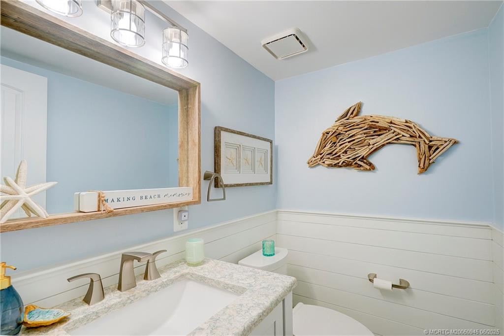 245 Northeast MacArthur Boulevard, Unit 11 Stuart, FL 34996 - Photo 27 of 47 a bathroom with a sink a toilet and mirror