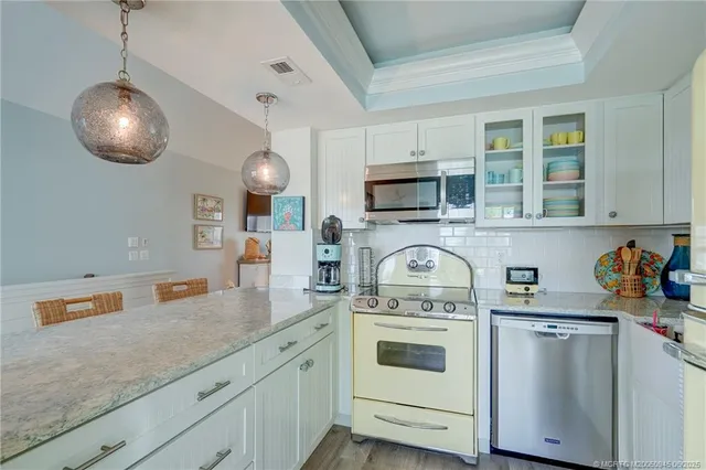 a kitchen with stainless steel appliances granite countertop a sink a stove and cabinets