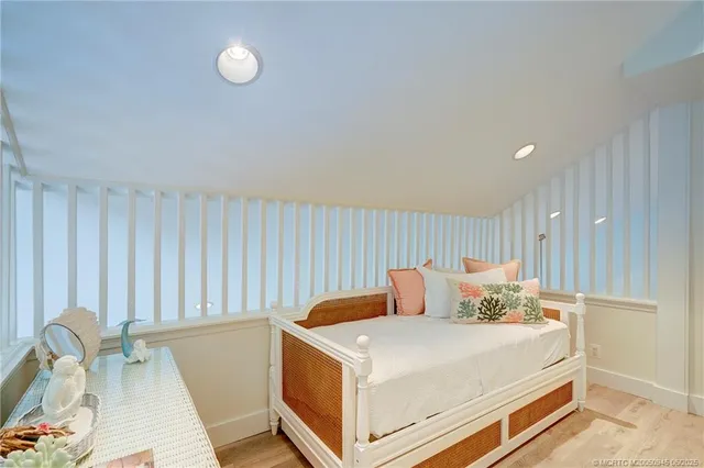 a white bed sitting in a room next to a window