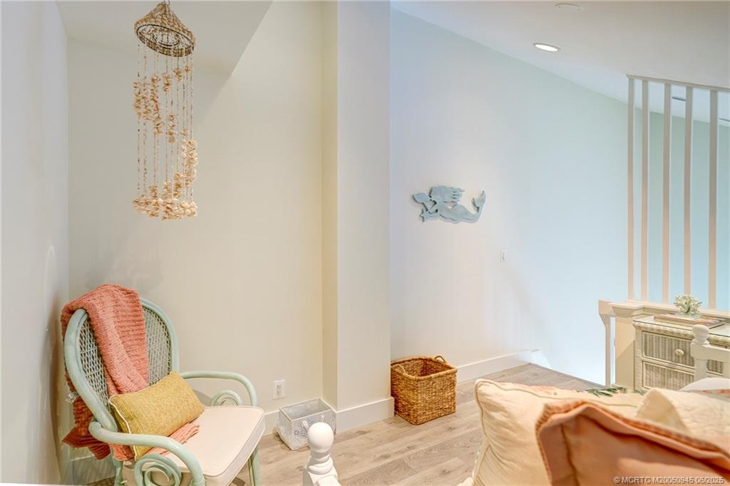 245 Northeast MacArthur Boulevard, Unit 11 Stuart, FL 34996 - Photo 35 of 47 a bedroom with a bed and wooden floor