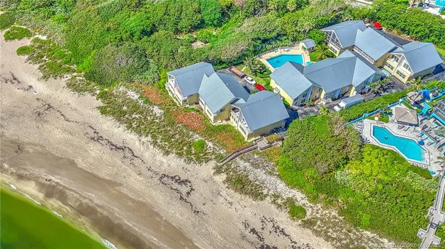 an aerial view of a house with swimming pool and garden