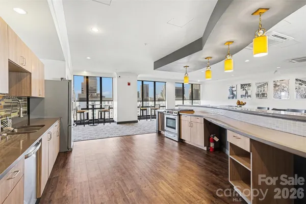 a large kitchen with stainless steel appliances kitchen island granite countertop a large counter top space a sink stainless steel appliances and cabinets