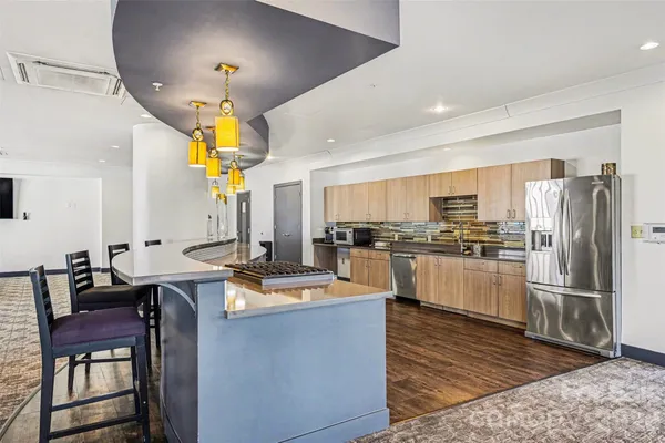 a kitchen with stainless steel appliances granite countertop a sink a stove and refrigerator