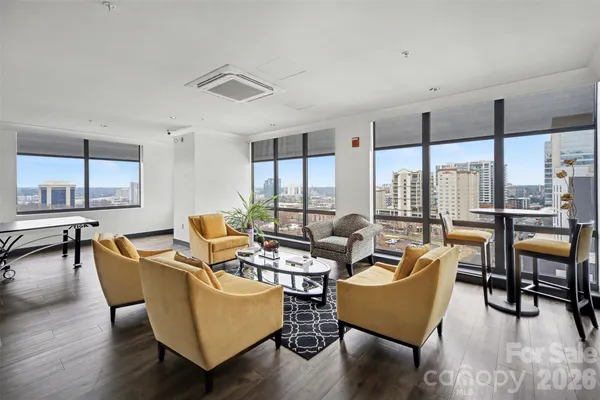 a living room with furniture kitchen view and large windows