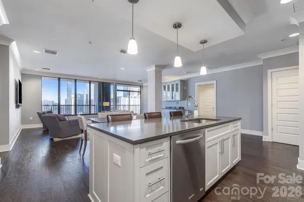 a kitchen with stainless steel appliances granite countertop a sink a stove and a wooden floors