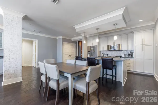 a kitchen with a dining table chairs and wooden floor