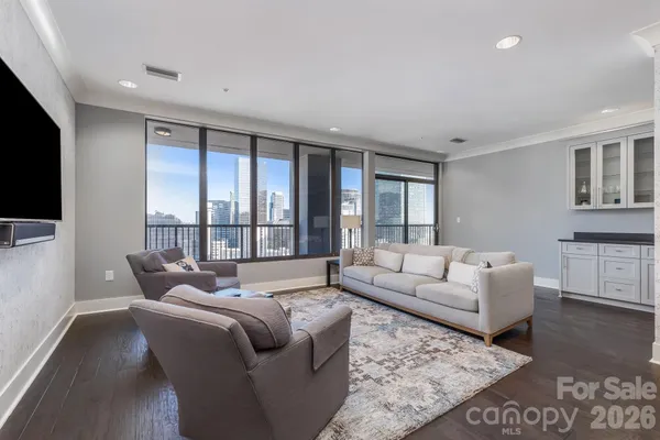 a living room with furniture large windows and a flat screen tv