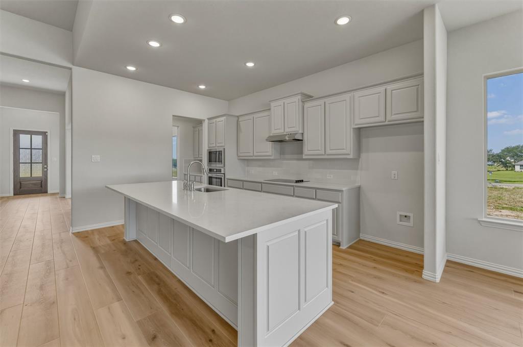 605 Tay Tay Way Springtown, TX 76082 - Photo 7 of 31 Expansive kitchen island with a light-colored countertop and integrated sink