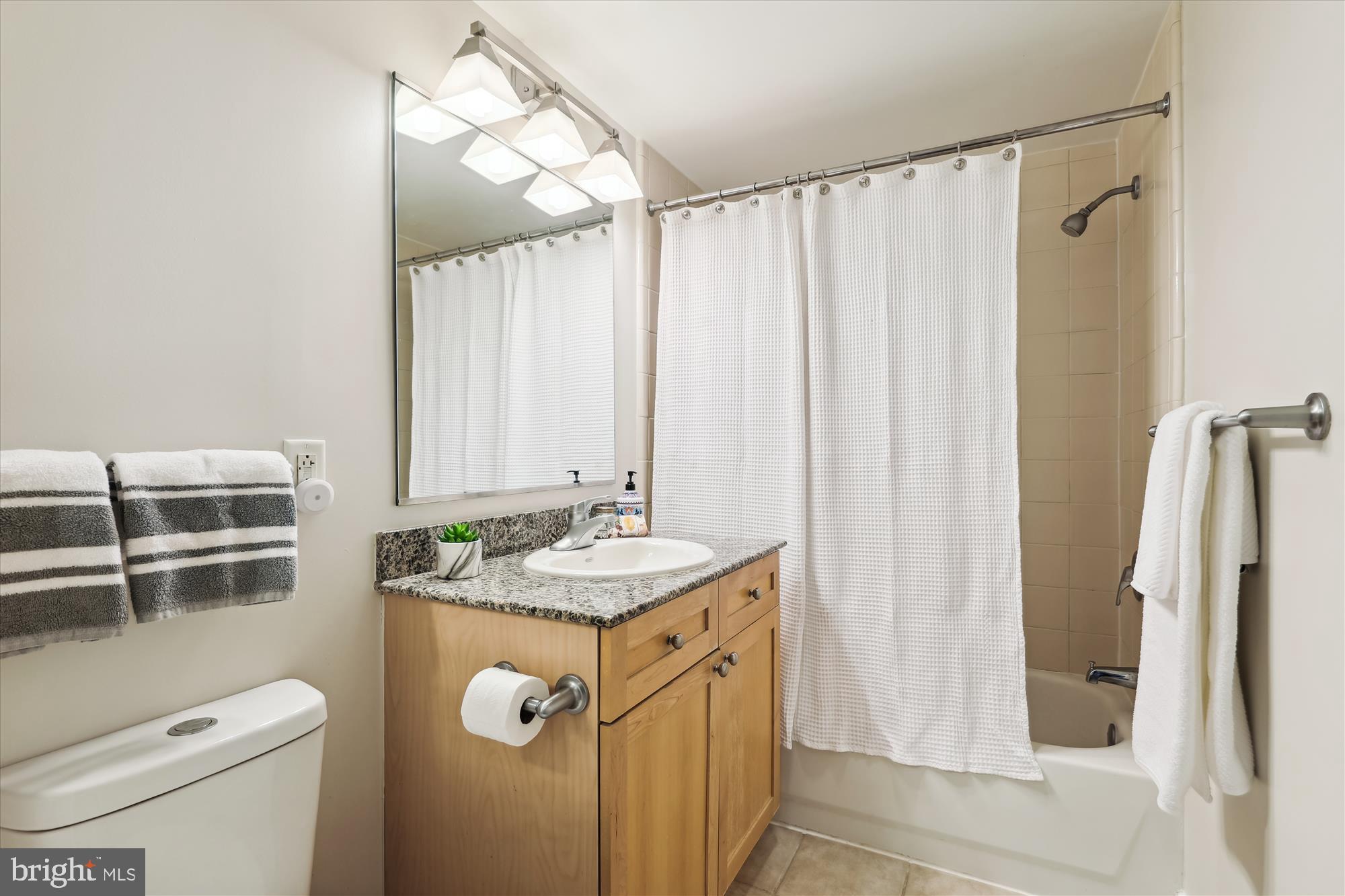 777 7th Street Northwest, Unit 804 Washington, DC 20001 - Photo 24 of 58 a bathroom with a granite countertop sink toilet and shower