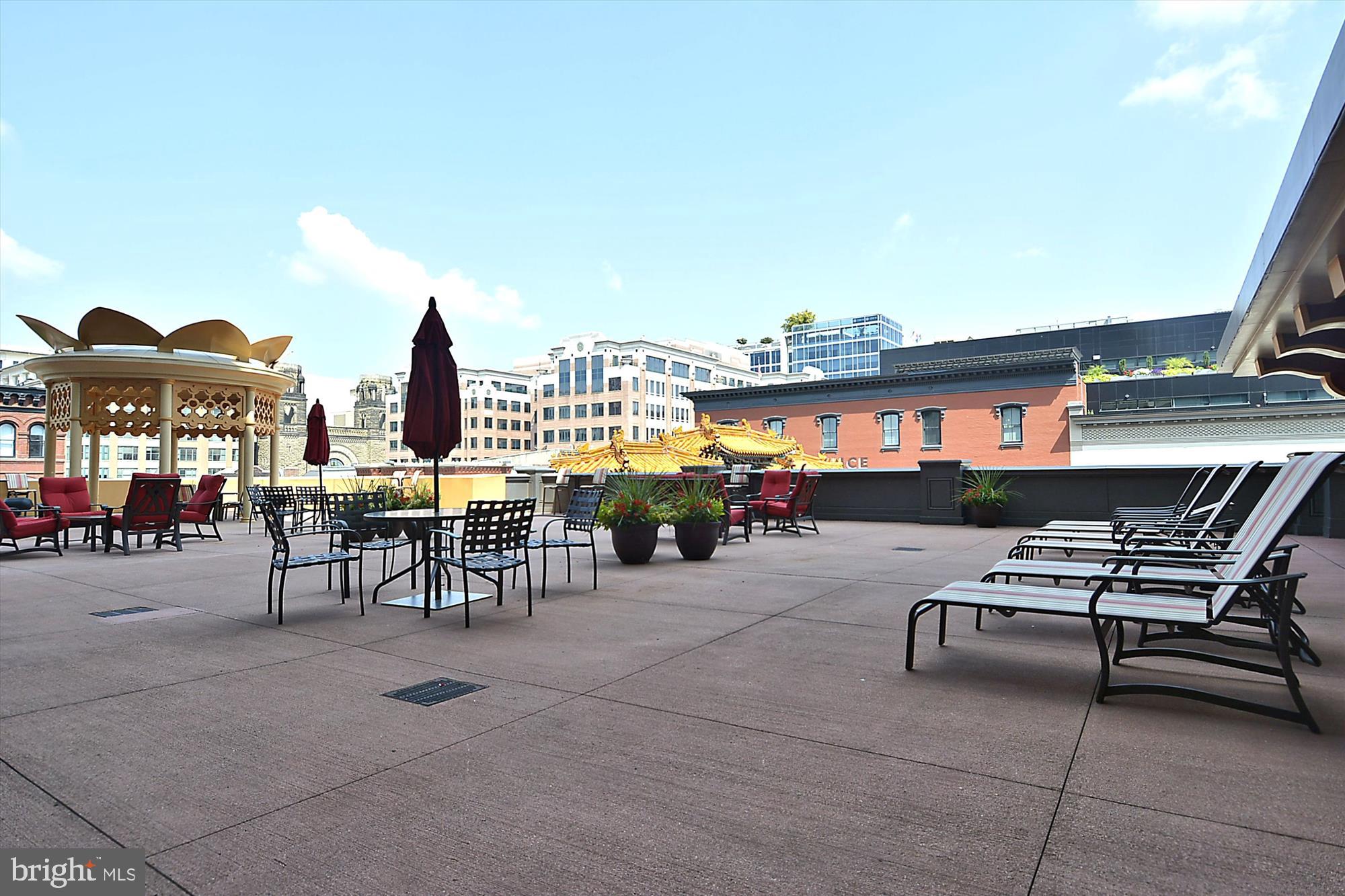 777 7th Street Northwest, Unit 804 Washington, DC 20001 - Photo 39 of 58 a view of a patio with dining table and chairs under an umbrella with a fire pit