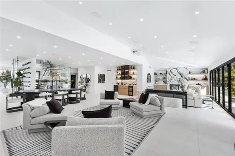 a kitchen with stainless steel appliances kitchen island a table chairs in it and white cabinets