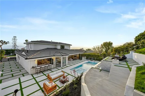 a large white kitchen with stainless steel appliances kitchen island granite countertop a refrigerator and a sink