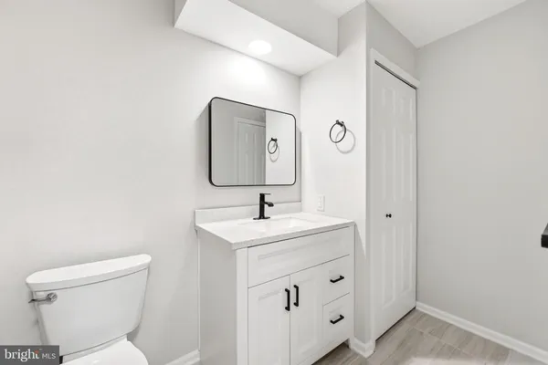 a bathroom with a toilet a sink and mirror
