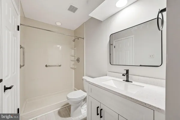 a bathroom with a sink toilet a mirror and shower