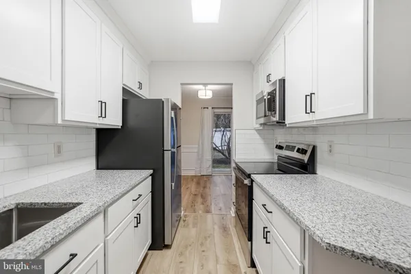 a kitchen with a sink dishwasher a refrigerator and wooden cabinets