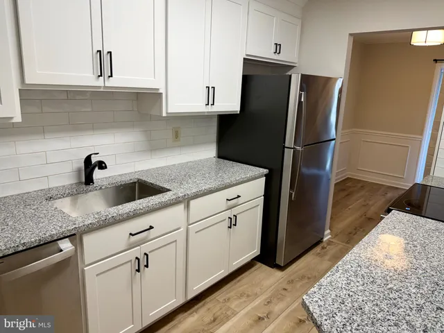 a kitchen with stainless steel appliances granite countertop a refrigerator sink and stove