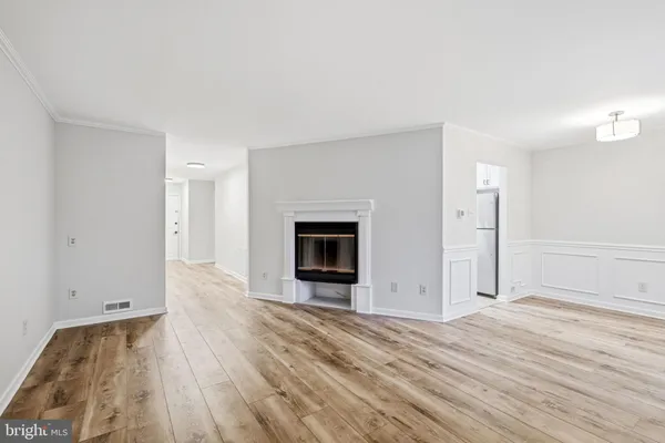 an empty room with wooden floor and fireplace