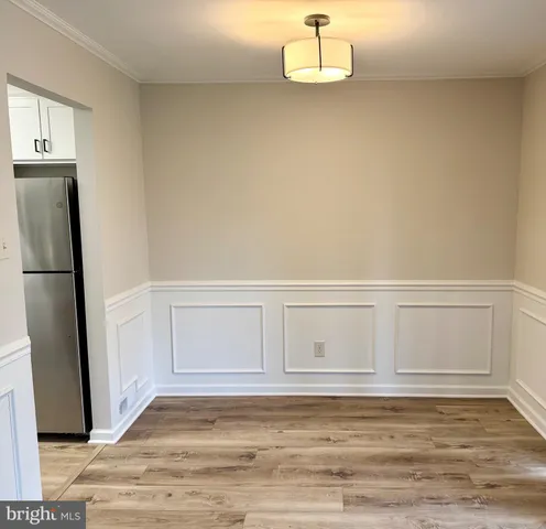 a view of empty room with cabinet and wooden floor