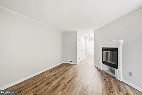a view of a room with wooden floor and a ceiling fan