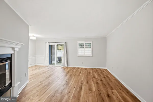 a view of a livingroom with wooden floor and a fireplace
