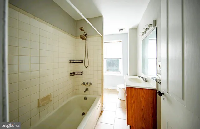 a bathroom with a tub shower and sink