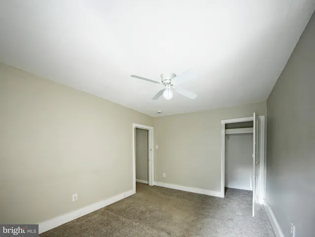an empty room with closet and windows