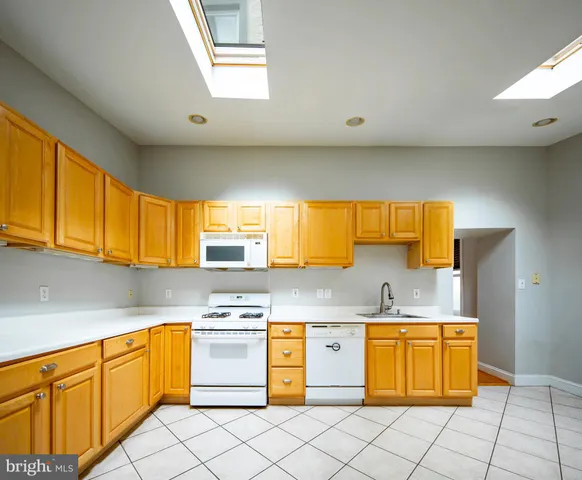 a kitchen with granite countertop a sink counter top space cabinets and stainless steel appliances