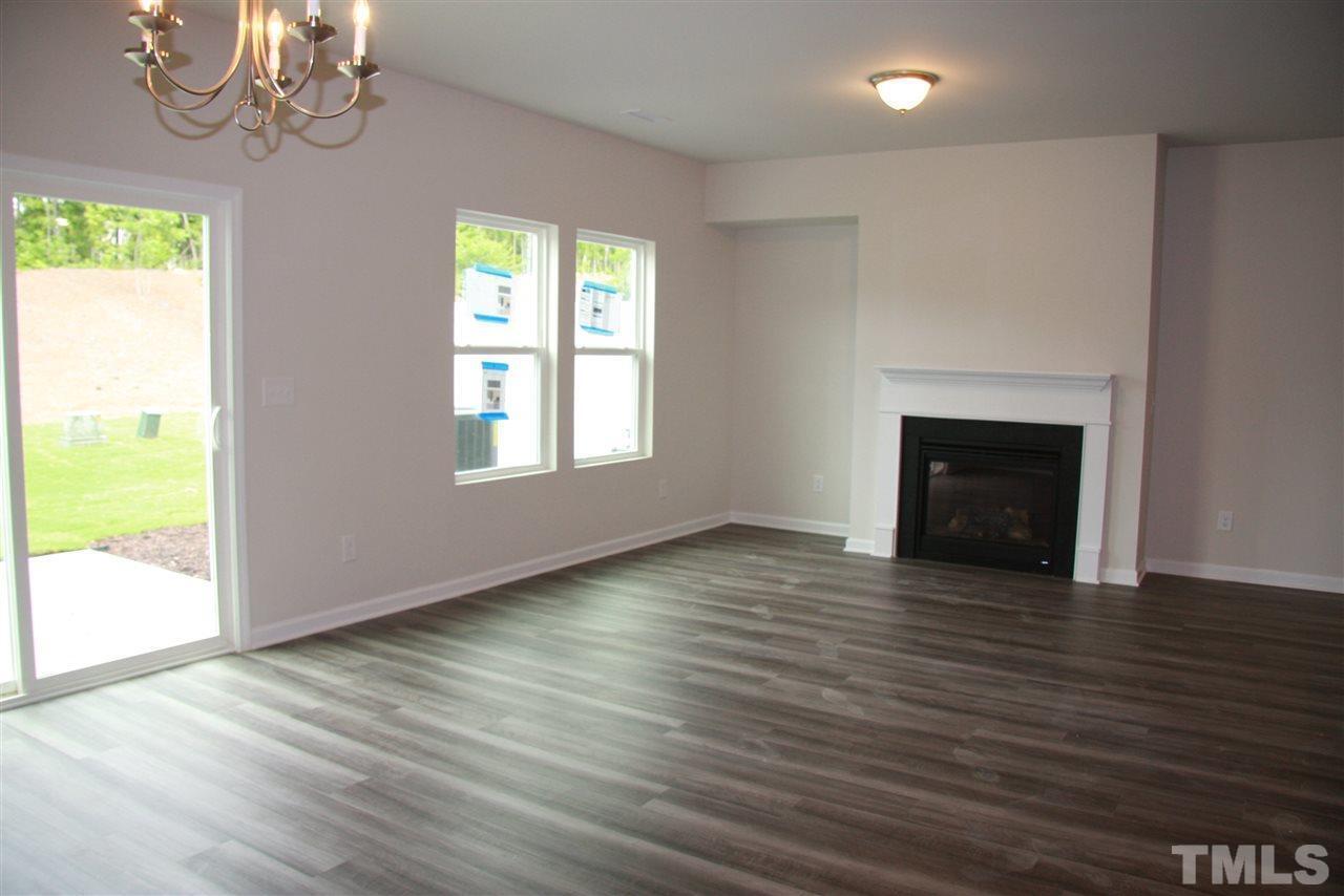 1154 Chestnut Bluff Apex, NC 27502 - Photo 4 of 26 an empty room with wooden floor chandelier and windows