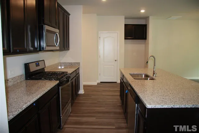 a kitchen with granite countertop stainless steel appliances and wooden cabinets