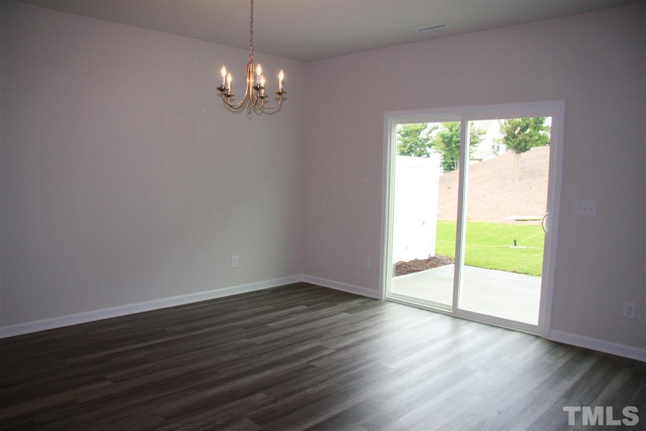 1154 Chestnut Bluff Apex, NC 27502 - Photo 9 of 26 a view of an empty room with wooden floor and a window