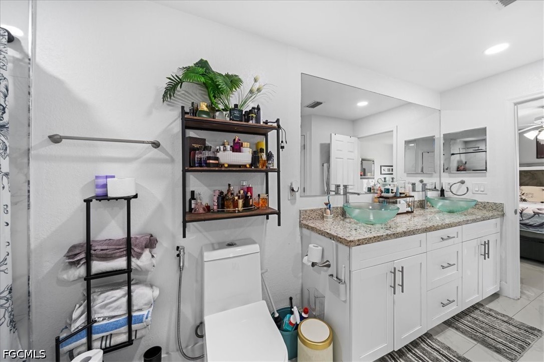 22 Nelson Road South Cape Coral, FL 33991 - Photo 30 of 43 a bathroom with a granite countertop toilet sink and mirror