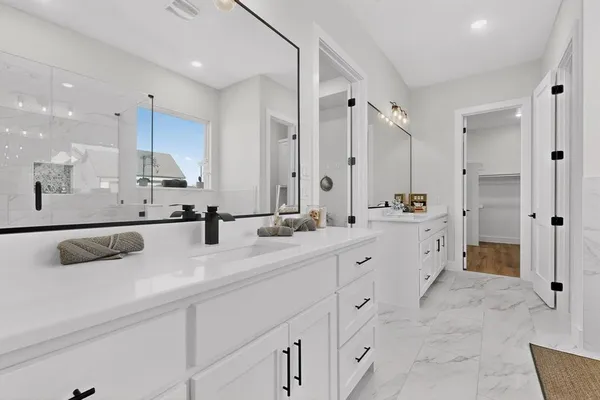 a bathroom with double vanity sink and mirror