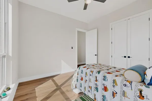 a bedroom with a bed and wooden floor