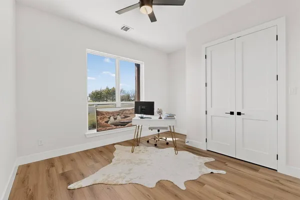a view of a workspace with furniture and wooden floor